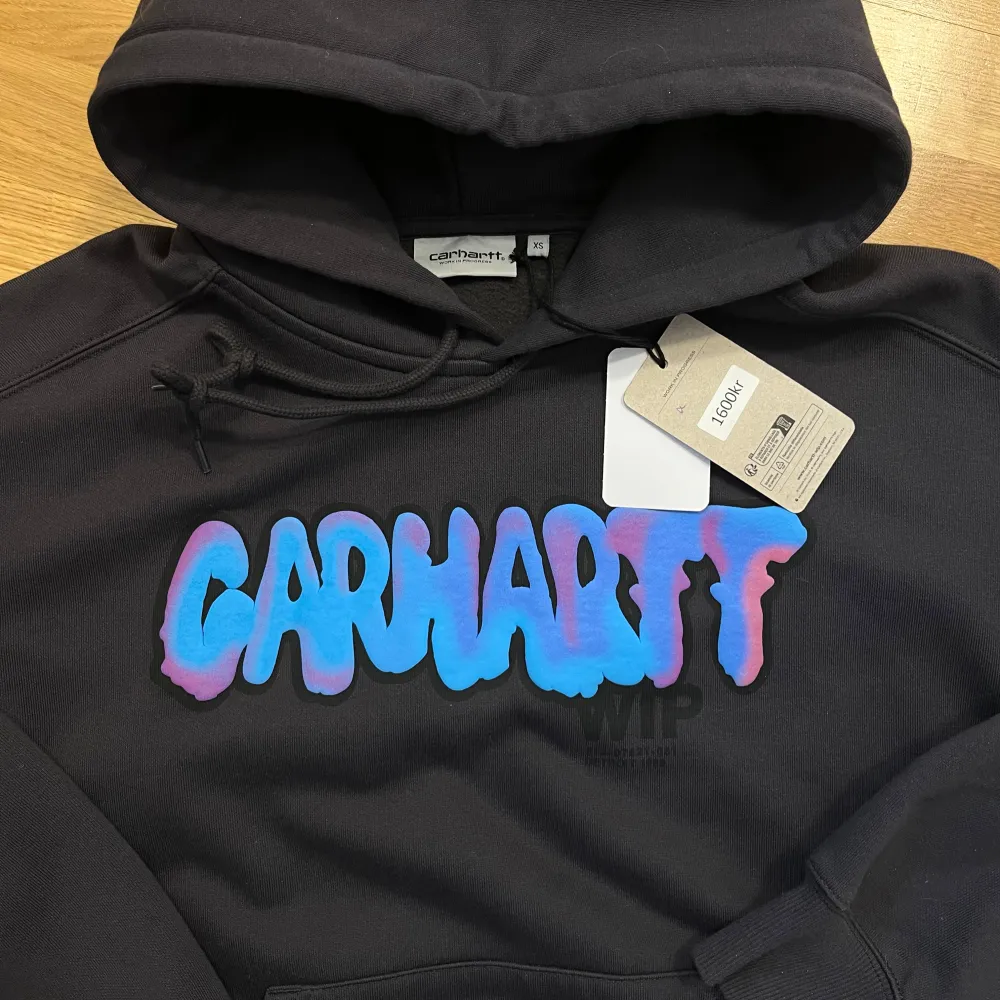 Carhartt hoodie, helt ny med prislappen kvar! Den har bara hängt i min garderob i några månader och tyvärr aldrig kommit till användning :) färgen är lite svår att beskriva men den är grå/svart, typ stentvättad.. Hoodies.