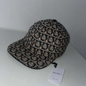  Salvatore Ferragamo - Ferigamo keps, Äkta tags o kvitto finns. Använt 1-2 gånger pågrund av ej min stil, odenarie pris runt 3500kr, Mitt pris 1200kr. Pris kan ändras vi snabbt och enkel affär.