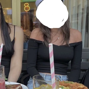 Svart långärmad topp från Gina  - Snygg svart långärmad topp från Gina med offshoulder-design. Perfekt för en stilren look och kan matchas med både jeans och kjol. 