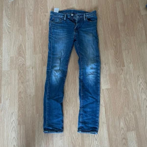 Levis 510 jeans - Snygga Levis 510 jeans i blå denim med en tight passform. De har klassiska fem fickor och en dragkedja med knappstängning. Perfekta för en stilren look.