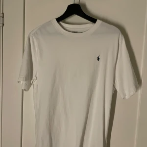 Vit t-shirt från Polo Ralph Lauren - Säljer en klassisk vit t-shirt från Polo Ralph Lauren med korta ärmar och en liten broderad logga på bröstet. Perfekt för en stilren och avslappnad look. Tillverkad i mjuk bomull för extra komfort. Knappt använd då jag köpte fel storlek.