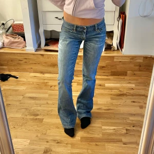Lågmidjade Bootcut jeans  - Snygga blå jeans från Armani Exchange med en bootcut-stil. De har en klassisk femficksdesign och är lågmidjade. Perfekta för en avslappnad look. Midjemåttet är 36 cm rakt över och innerbenslängden ca 83 cm! 