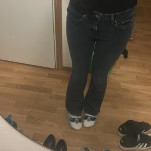 Mörkblå jeans med bootcut - Snygga mörkblå jeans med bootcut-stil och låg midja. Perfekta för en avslappnad look. Klassisk femficksdesign med knapp och dragkedja framtill.