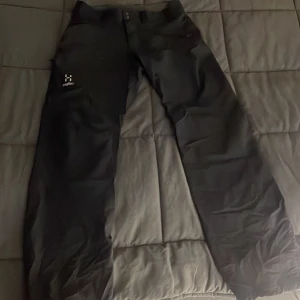 Svarta byxor från Haglöfs - Säljer ett par svarta byxor från Haglöfs. De har en rak passform och är perfekta för utomhusaktiviteter. Byxorna har en knapp och dragkedja framtill. Bra skick storlek s