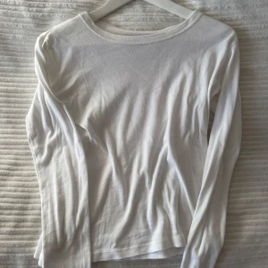 Vit långärmad tröja från brandy Melville - Säljer en enkel och stilren vit långärmad tröja. Perfekt för lager-på-lager eller som basplagg i garderoben. Tröjan har en rund halsringning och är gjord i ett mjukt material.