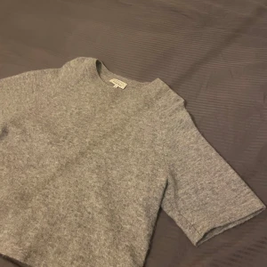 Grå stickad tröja från other stories  - Mysig grå stickad tröja från other stories med trekvartsärm. Perfekt för kyligare dagar och enkel att matcha med olika outfits. Tröjan har en rund halsringning och en avslappnad passform. Pris kan diskuteras, skriv för fler bilder 