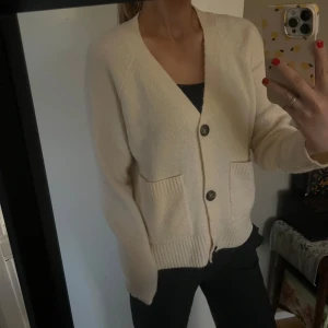 Beige kofta med knappar - Säljer en mysig beige kofta med knappar framtill och två fickor. Perfekt för kyliga dagar och lätt att matcha med olika outfits.