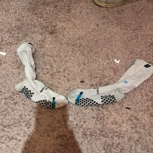 Skillsocks pro flex - Säljer ett par vita strumpor från SkillSock med svarta prickar och blå detaljer. Strumporna har texten 'FLEX' och 'SKILLSOCK' tryckt på sidan. Perfekta för sport och träning. Strl 39-42