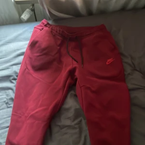 Vinröda nike tech byxor - Säljer ett par vinröda nike tech byxor har bara använt några gånger