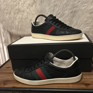 Gucci Ace skor - Säljer ett par eftertraktade svarta Gucci Ace skor | De är i stolek 41,5 men passar något större | Box, vita snören samt kuvert medföljer | Fraktar 1-2 dagar efter köp via PostNord eller instabox🚙✉️ | Har du frågor eller funderingar hör gärna av dig🙌