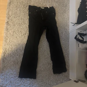 Svarta bootcut byxor från Zara - Snygga svarta bootcut byxor från Zara. De har en klassisk design med knappar och dragkedja framtill. Perfekta för en stilren look.