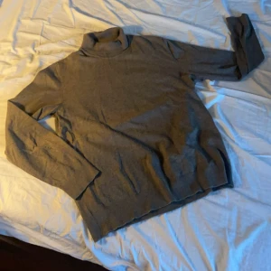 Grå polotröja från Lindbergh - Säljer en stilren grå polotröja från Lindbergh. Tröjan har långa ärmar och en klassisk polokrage, perfekt för kyligare dagar. Den är tillverkad i ett mjukt material som ger en bekväm passform. Storlek XL men sitter som L