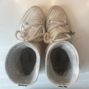 Crémefärgade Inuikiis - Jättefina inuikkiis, de är i något tyg liknande material. De är slitna inuti men går fortfarande att brukas. Skriv för frågor.
