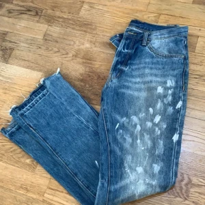 Blå jeans med slitna detaljer från mnmi  - Säljer ett par blå jeans med coola slitna detaljer och fransar vid bensluten. Jeansen har en straight passform och är perfekta för en avslappnad stil finns ingen skador absolut 💯 den är helt ny har inte använda den mycket 
