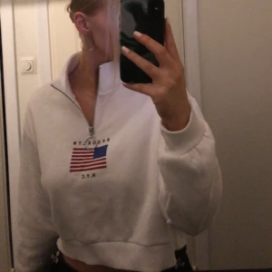 Vit croppad tröja från H&M Divided - Säljer en vit croppad tröja från H&M Divided med dragkedja och tryck på bröstet. Endast använd ett fåtal gånger