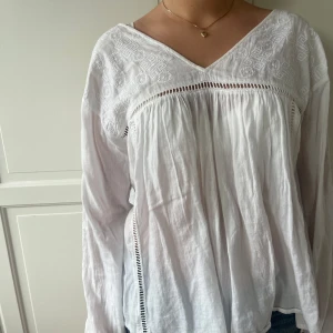 Vit sommrig blus med låg rygg och blomdetaljer - Jag säljer min vita långarmade luftiga blus med blom detaljer och låg rygg🌸🌸