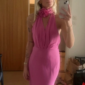 Klänning - Så magiskt fin satin klänning från Zara. Öppen rygg och perfekt längd. Bandet med rosen går att knyta runt halsen eller midjan😍🌸  perfekt klänning till bröllop eller liknande fina tillställningar! Endast använd en gång