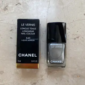 Säljer ett superlyxigt nagellack från Chanel i färgen 540 Liquid Mirror. Det är en långvarig nagelfärg som ger en spegelblank finish. Flaskan innehåller 13 ml och kommer i en elegant svart förpackning med guldiga detaljer. Perfekt för en glamorös look!