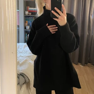 Svart stickad tröja - Svart stickad tröja med polokrage och slits på sidan från H&M i storlek M.