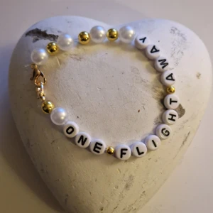 Marcus och Martinus armband med låttext * FAN MERCH  - Unikt armband med vita bokstavspärlor som bildar texten 'ONE FLIGHT AWAY'. För alla Marcus och Martinus fans! 