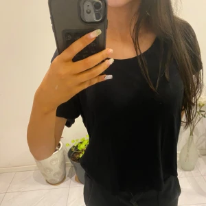 Svart t-shirt från 157 - Säljer en enkel och stilren svart t-shirt från 157. T-shirten har en normal passform och korta ärmar, perfekt för vardagsbruk. Den är tillverkad i ett mjukt och bekvämt material.