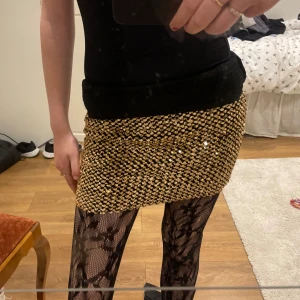 Glittrig kortkjol i guld - Snygg glittrig kortkjol i guld med paljetter. Kjolen har en tight passform och dragkedja på sidorna, jag personligen hade kjolen med en längre stickad tröja så att dragkedjorna inte syns!💕