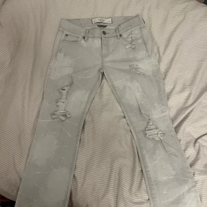 Grå vintage lågmidjade jeans - Snygga grå jeans från Abercrombie & Fitch med slitningar på framsidan och bakfickor. Supercoola jeans som tyvärr är försmå för mig. De är lågmidjade och raka i modellen. Aldrig använda därav i toppenskick!