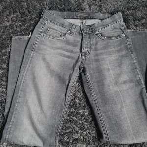 Grå jeans från Acne Jeans - Snygga grå jeans från Acne Jeans med klassisk femficksdesign. De har en normal passform och är perfekta för en stilren look. Jeansen har en dragkedja och knapp framtill.