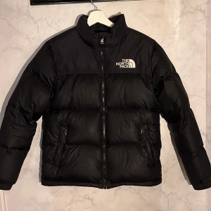 Svart dunjacka från The North Face - Säljer en svart dunjacka från The North Face i ungdomsstorlek XL.  Men jag som använder den är 168 lång och min normala storlek är M. 