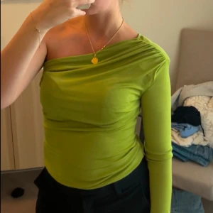 Grön oneshoulder topp - Snygg grön oneshoulder topp använd en gång. 