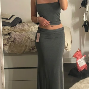 Grå långkjol - Säljer min helt oanvända grå low waist långkjol från nelly. Lappen är kvar och just denna är helt slutsåld. Kontakta vid intresse, ps går inte ner i pris. 🤍