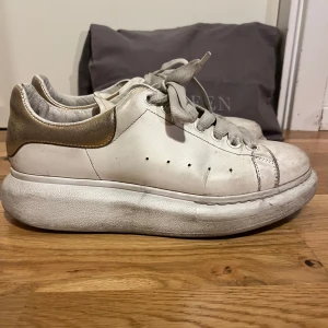 Oversized sneakers Alexander McQueen - Oversized sneakers från Alexander McQueen med guldetaljer baktill. Som syns på bilderna är de väldigt smutsiga men bortsett från förslitningar i hälen och repor vid tårna och baktill är de hela! Priset reflekterar skicket men tror att en skomakare skulle kunna göra underverk! (Ex. Hallmans skomakeri på NK är duktiga på att återställa märkesskor) Skicka ett meddelande om du undrar något! Saknar kvitto men har skornas serienummer. 