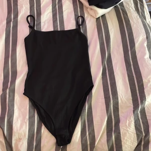 Svart body från Gina Tricot - Säljer nu en svart body från Gina Tricot. Aldrig använt den här bara legat här hemma då den är för liten för mej. Storlek S. Hör av dej vid intresse eller för mer info. Köparen betalar frakt💕