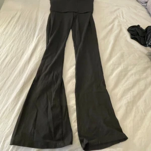 Svarta byxor från Gina Tricot - Snygga svarta byxor från Gina Tricot med bootcut-stil. Perfekta för en trendig look. Byxorna har en bekväm passform och är tillverkade i ett mjukt material. aldrig använda