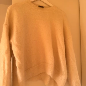 Vit stickad tröja från Axel Arigato - Säljer en stilren beige stickad tröja från Axel Arigato. Använd fåtal gånger