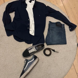 Marinblå skjorta från Ralph Lauren - Skjorta från RL. Använd tre gånger sedan jag köpte den i våras. En missfärgning på baksidan av ena ärmen men ingenting som syns vid användning. Går förmodligen bort i tvätten eller med andra medel. Pris kan diskuteras. Slimfit.