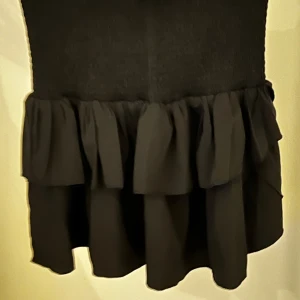 Svart kjol från Neo Noir - Snygg svart kjol från Neo Noir med volangdetaljer. Perfekt för att ge en stilfull touch till din outfit.