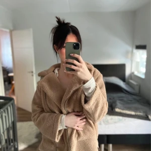 Beige teddyjacka från Topshop - Mysig beige teddyjacka från Topshop i storlek S. Jackan har en dragkedja framtill och en klassisk krage. Perfekt för kyligare dagar med sin mjuka och varma design.