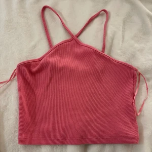 Rosa linnetopp från Zara - Snygg rosa ribbad linnetopp från Zara med smala band som korsars runt halsen. Knappt använd, storlek M passar även S!