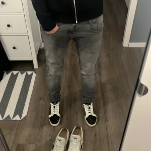 Gråa Replay Anbass - Snygga grå jeans med en slim passform. Perfekta för en stilren look. De har en klassisk design med fem fickor och knappgylf. Nästintill nyskick.