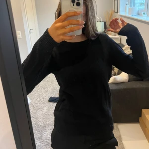 Svart stickad tröja - Säljer en stilren svart stickad tröja med långärmad design från vila. Perfekt för kyligare dagar och enkel att matcha med olika outfits.