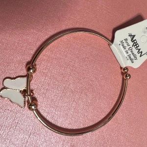 Guldarmband med fjärilsberlock barn - Elegant guldarmband från Urban med en vit fjärilsberlock. Perfekt för att lägga till en subtil touch av elegans till din stil. Tillverkat i Indien.