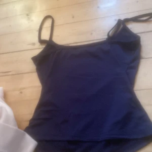 Mörkblå linnetopp - Snygg mörkblå linnetopp med smala axelband. Perfekt för varma sommardagar eller som ett lager under en tröja. Enkel och stilren design som passar till det mesta.