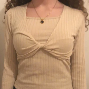 Beige ribbad topp från Zara - Säljer en beige ribbad topp från Zara med lång ärm och en snygg twistdetalj framtill. Perfekt för en stilren look.Two piece 