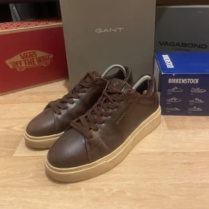Bruna sneakers från GANT - Snygga bruna sneakers från GANT i skinn med snörning. En stilren design som passar perfekt till vardags, som fortfarande är formell.                          - En sko som både passar män och kvinnor under alla årstider.                                                                     - Lite använd, under 10 gånger                                    - Låda ingår                                                                     - Köpt den Zalando