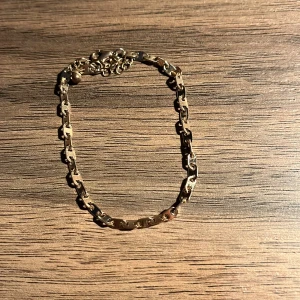 Guldarmband med kedjedesign - Elegant guldarmband med unik kedjedesign. Perfekt för att lägga till en touch av stil till din outfit. Armbandet har en justerbar kedja för att passa olika storlekar.