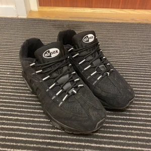 Nike air max 95 - Säljer ett par svarta Nike Air Max med snygg design och bekväm passform. Skorna har en synlig Air-enhet i sulan och snörning framtill. Perfekta för både stil och komfort. SKRIV INNAN KÖP