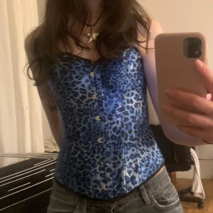 Blå leopardmönstrad korsett - Jättesnygg blå korsett med leopardmönster. Den har snörning i ryggen för en justerbar passform. Köpt vintage 💞