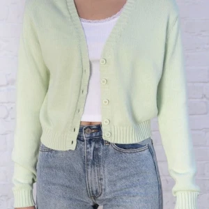 Ljusgrön kofta med knappar - Stickad kofta från Brandy melville med knappar framtill. Koftan är ljus grön/ mint grön och v-ringad. Färgen och designen på koftan/ tröjan har en vintage look. Storleken är onesize men passar XXXS-L beroende på vilken passform man vill ha. Super fin och trendig och säljs inte längre på brandy melville