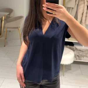 Mörkblå v-ringad blus - Snygg mörkblå blus med v-ringning och korta ärmar. Denna är använd endast en gång. FINNS ÄVEN I LJUSROSA!